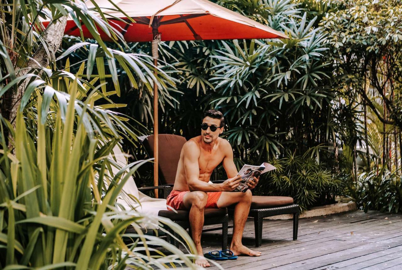 Shangri-La クアラルンプール エクステリア 写真 A man reading a book at a resort