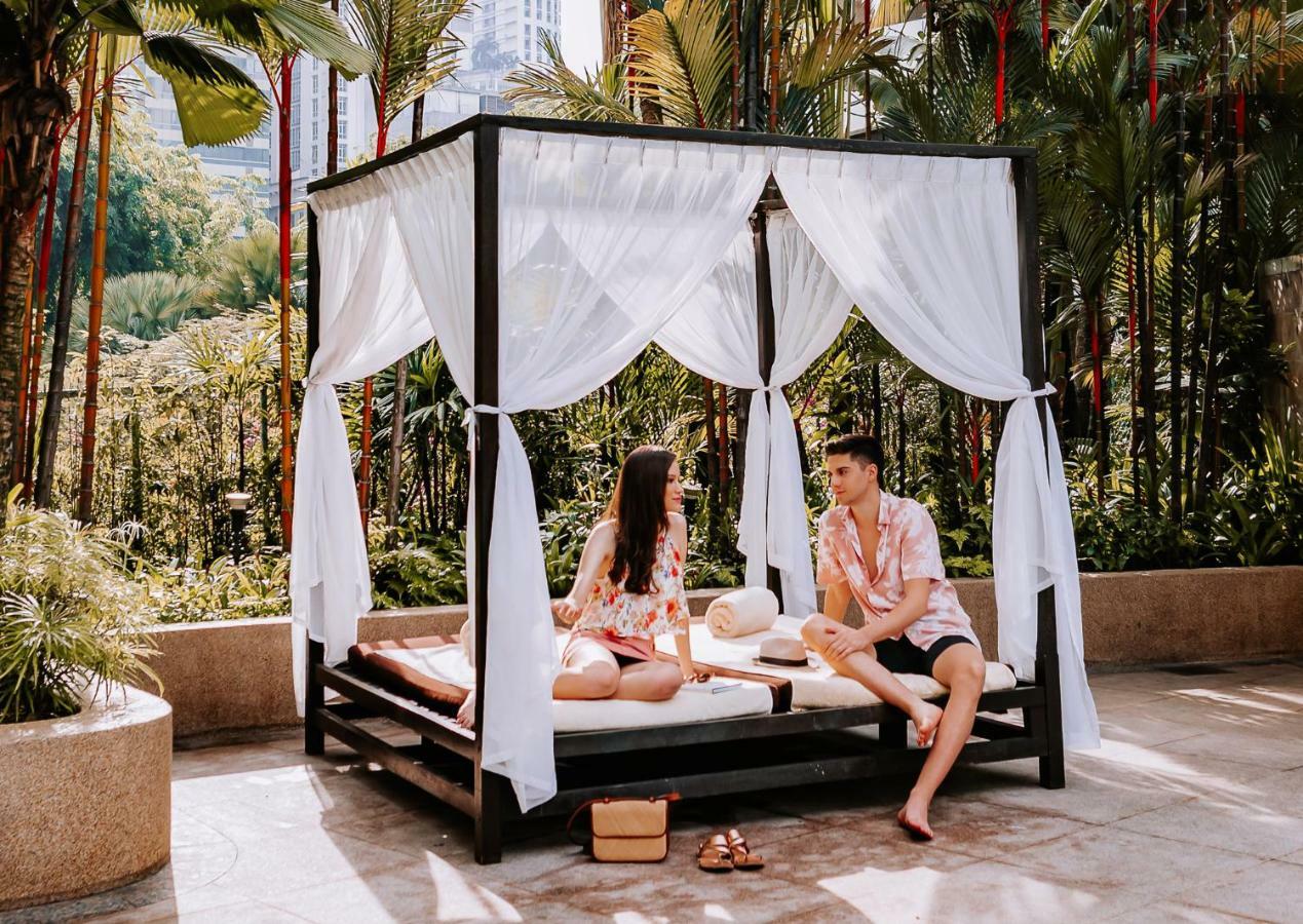 Shangri-La クアラルンプール エクステリア 写真 A couple relaxing at the poolside of the hotel